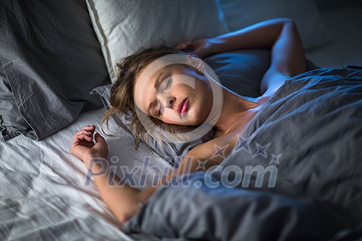 Beautiful young woman sleeping in bed (colour toned image; shallow DOF)