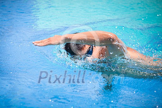 Young man swimming the front crawl/freestyle in a pool Young man swimming the front crawl/freestyle in a pool