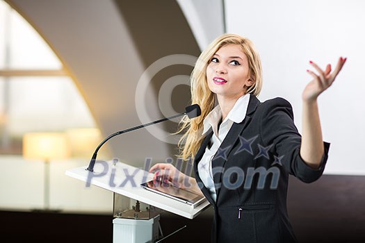 Pretty, young business woman giving a presentation in a conference/meeting setting (shallow DOF; color toned image) Pretty, young business woman giving a presentation in a conference/meeting setting (shallow DOF; color toned image)