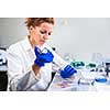 Portrait of a female researcher carrying out research in a chemistry lab (color toned image; shallow DOF)