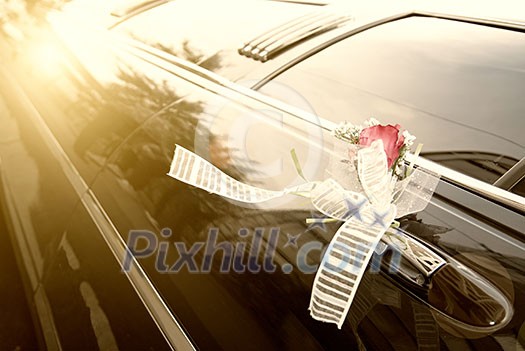 Door of black wedding car with flower and ribbon Door of black wedding car with flower and ribbon