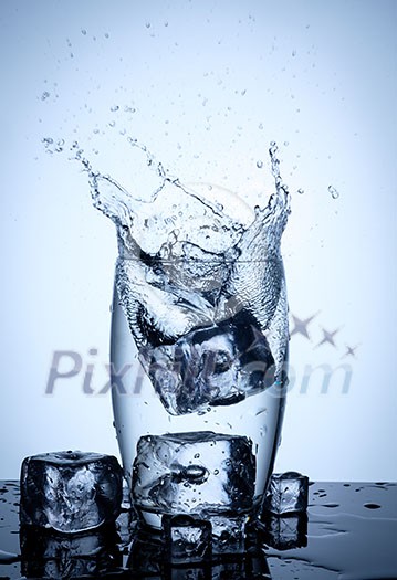 Water splash in glass with ice cubes. Water splash in glass with ice cubes.