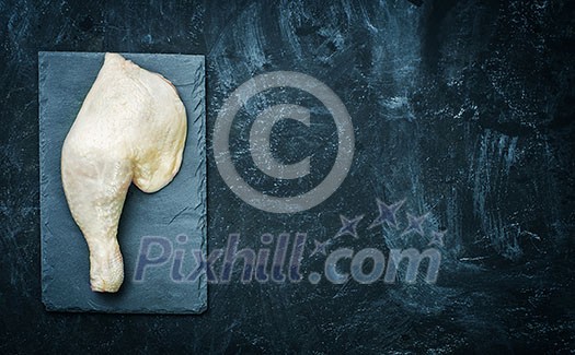 Raw chicken thigh on black stone plate. Copyspace. Raw chicken thigh on black stone plate. Copyspace.