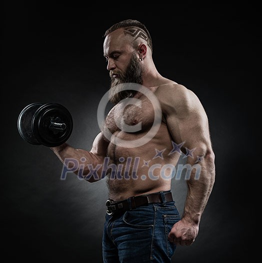 Strong bodybuilder with six pack, perfect abs, shoulders, biceps, triceps and chest. Power athletic bearded man in training pumping up muscles with dumbbell. Strong bodybuilder with six pack, perfect abs, shoulders, biceps, triceps and chest. Power athletic bearded man in training pumping up muscles with dumbbell.