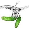 green cucumbers dropped into water isolated on white