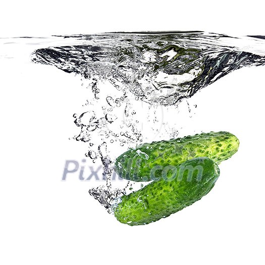 green cucumbers dropped into water isolated on white green cucumbers dropped into water isolated on white