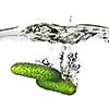 two green cucumbers dropped into water isolated on white