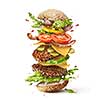 Delicious monster burger with flying ingredients isolated on white background