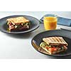 Breakfast Club Sandwich with orange juice on a table