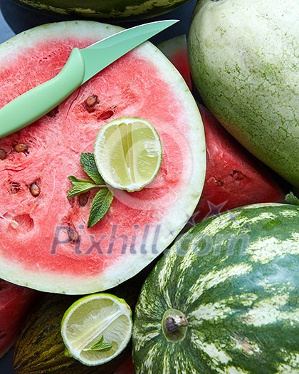 Background of fresh ripe watermelon slices with knife, slice lime and mint Background of fresh ripe watermelon slices with knife, slice lime and mint