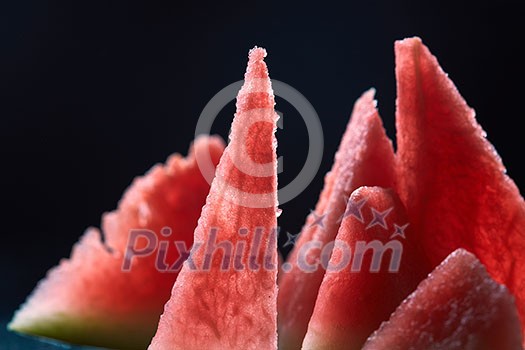 Triangle shaped watermelon slices on dark grungy background . Top view. Triangle shaped watermelon slices on dark grungy background . Top view.