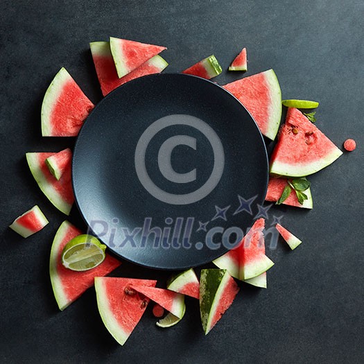 slices of watermelon placed in a circle of black plate. Space for text slices of watermelon placed in a circle of black plate. Space for text