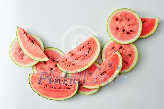 many slices of watermelon on a light background