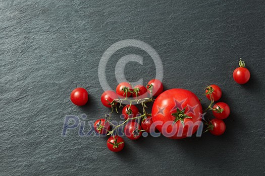Tomatoes bunch on a black concrete background Tomatoes bunch on a black concrete background