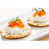 Closeup of caviar and cream cheese appetizer on crackers