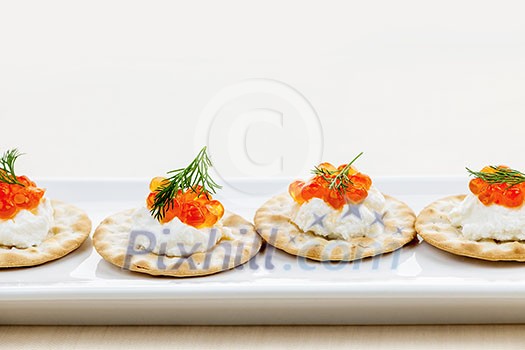 Caviar appetizer with goat cheese and crackers on white plate Caviar appetizer with goat cheese and crackers on white plate