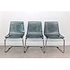 Three gray transparent plastic and metal chairs in a row