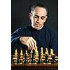 Man moving a chess piece on wooden chessboard