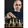 Man moving a chess piece on wooden chessboard