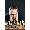 Chessboard with man thinking about chess strategy