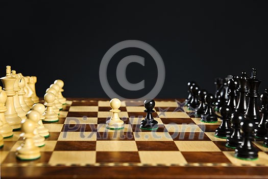 Close up of chess pieces on wooden chessboard Close up of chess pieces on wooden chessboard