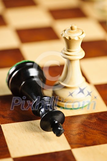 Closeup of checkmate on king by queen winning in chess game Closeup of checkmate on king by queen winning in chess game