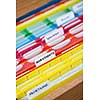 Open file folder drawer with many multicolored files containing personal finance documents