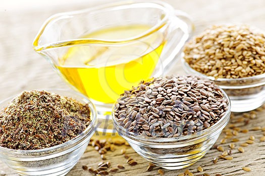 Bowls of whole and ground flax seed with linseed oil Bowls of whole and ground flax seed with linseed oil
