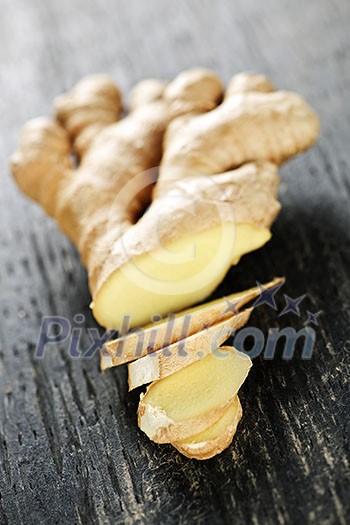 Close up of sliced fresh ginger root spice on wooden table Close up of sliced fresh ginger root spice on wooden table