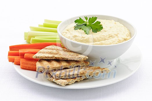 Healthy snack of hummus dip with pita bread slices and vegetables Healthy snack of hummus dip with pita bread slices and vegetables