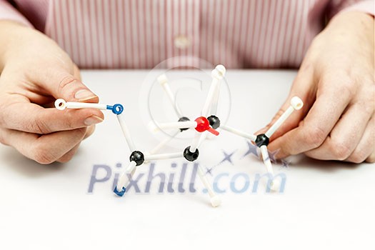 Hand of female student assembling amino acid molecule models for science project Hand of female student assembling amino acid molecule models for science project