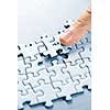 Finger pushing missing puzzle piece into place