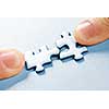 Fingers pushing two matching puzzle pieces together