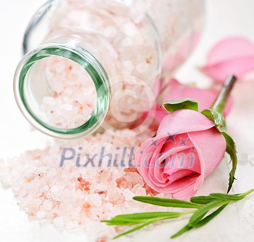 Pink bath salts in a glass jar with flowers and herbs Pink bath salts in a glass jar with flowers and herbs