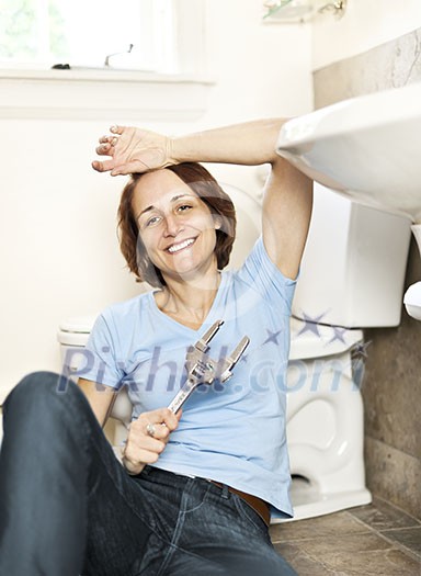 Woman repairing sink in bathroom at home Woman repairing sink in bathroom at home