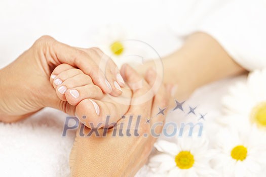 Female hands giving massage to soft bare foot Female hands giving massage to soft bare foot