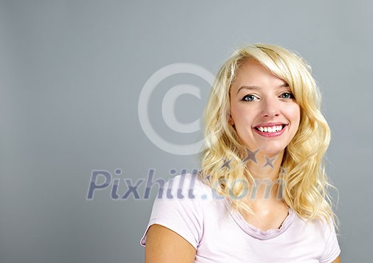 Portrait of smiling young blonde caucasian woman on grey background Portrait of smiling young blonde caucasian woman on grey background