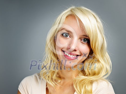 Portrait of smiling young blonde caucasian woman on grey background Portrait of smiling young blonde caucasian woman on grey background
