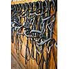 Leather horse bridles and bits hanging on wall of stable