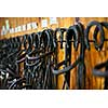 Leather horse bridles and bits hanging on wall of stable