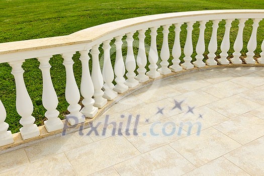 Fancy marble railing on ceramic tile patio with lawn Fancy marble railing on ceramic tile patio with lawn