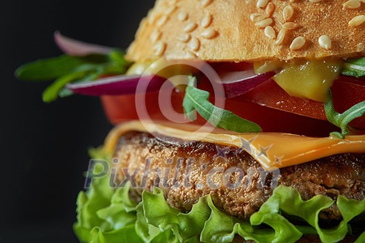 Close-up of home made tasty burger ona black Close-up of home made tasty burger ona black