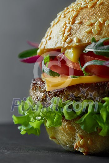 Close-up of home made tasty burger ona black Close-up of home made tasty burger ona black