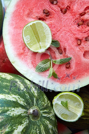 pieces of fresh watermelon as background with slice lime and mint pieces of fresh watermelon as background with slice lime and mint
