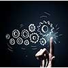 Business person hand touching gear mechanism representing interaction concept