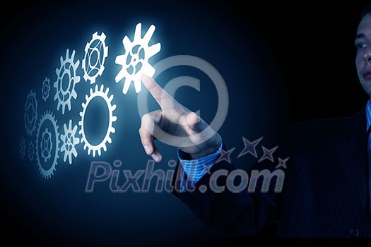 Business person hand touching gear mechanism representing interaction concept Business person hand touching gear mechanism representing interaction concept