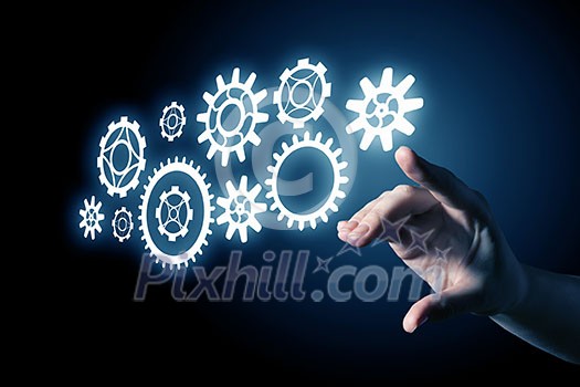 Business person hand touching gear mechanism representing interaction concept Business person hand touching gear mechanism representing interaction concept