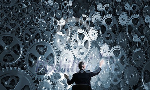 Young businessman sitting in chair and looking at gears mechanism Young businessman sitting in chair and looking at gears mechanism