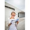 Happy young female tourist with map in the city (color toned image; shallow DOF)