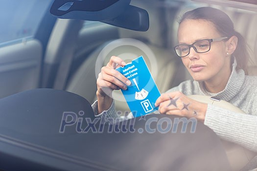Pretty, young woman driving her elegant new car - putting the necessary parking clock behind the windshield to park legally in a city (color toned image; shallow DOF) Pretty, young woman driving her elegant new car - putting the necessary parking clock behind the windshield to park legally in a city (color toned image; shallow DOF)